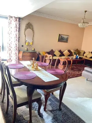 a dining room with a table and chairs and a couch at Luxury apartment 2 in the heart of Gueliz, Wifi, Pool in Marrakech
