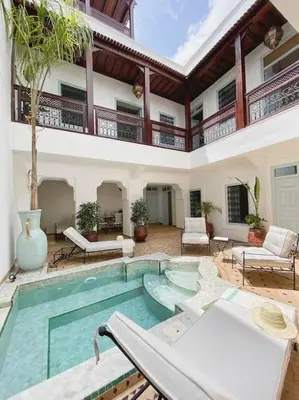 a house with a swimming pool in a courtyard at Riad Vivre - Design Boutique Riad in Marrakech in Marrakech