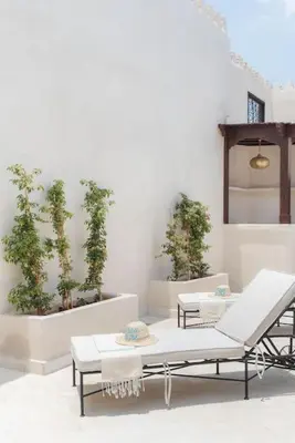 a room with tables and chairs and potted plants at Riad Vivre - Design Boutique Riad in Marrakech in Marrakech