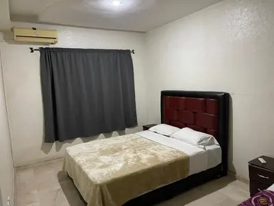 a bedroom with a bed with a red headboard and a window at Appartement 16 2èm étage ( POUR FAMILLE ) in Marrakech