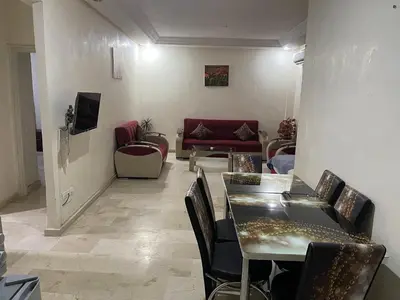 a living room with a couch and a table and chairs at Appartement 16 2èm étage ( POUR FAMILLE ) in Marrakech