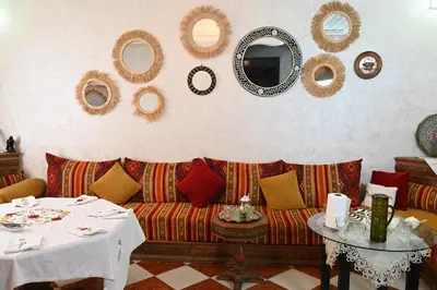 a living room with a couch and a table and mirrors at Riad sarsar airport in Marrakech