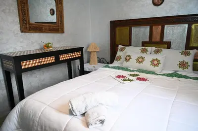 a bedroom with a large white bed with flowers on it at Riad sarsar airport in Marrakech
