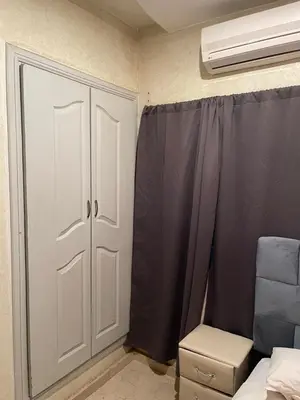 a bedroom with a closet and a bed and a fan at Appartement 19 3èm étage ( POUR FAMILLE ) in Marrakech