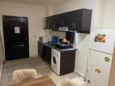 a small kitchen with a refrigerator and a stove at Appartement 22 au 3ème étage ( POUR FAMILLE ) in Marrakech