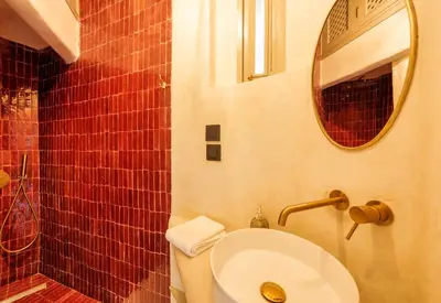 a bathroom with a toilet and a sink and a mirror at Riad XO in Marrakech