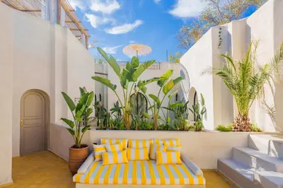a yellow and blue couch in a room with plants at Riad XO in Marrakech