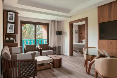 a living room with a couch and a table and a television at Le Meridien N'fis in Marrakech