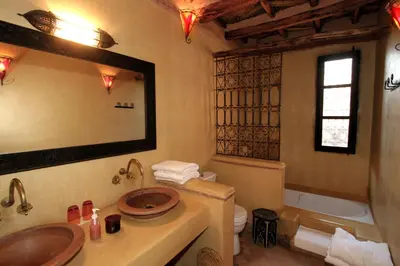 a bathroom with a sink and a toilet and a mirror at Jnane Leila in Marrakech