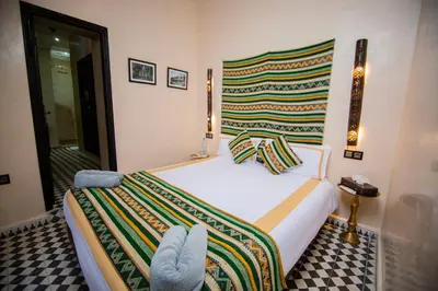 a bedroom with a bed with a colorful blanket on it at Riad Ta'achchaqa in Marrakech