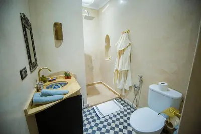 a small bathroom with a toilet and a sink at Riad Ta'achchaqa in Marrakech