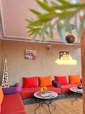 a living room with a red couch and two tables at Riad Shaden in Marrakech