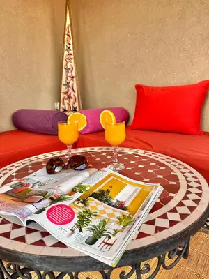 a coffee table with two glasses on top of a couch at Riad Shaden in Marrakech
