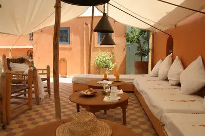 a hotel room with two beds and a table at Dar Touyir in Marrakech