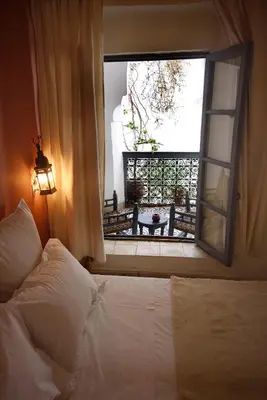 a bedroom with a bed and an open window at Dar Touyir in Marrakech
