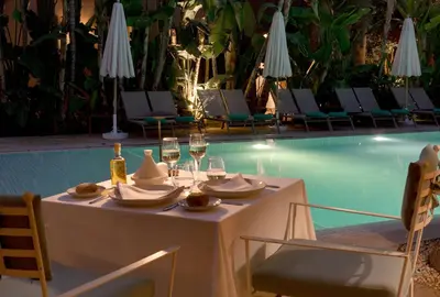 a table with wine glasses and napkins next to a pool at Les Jardins De La Médina in Marrakech