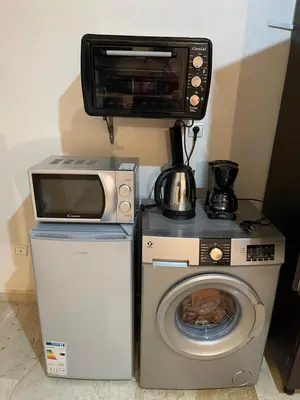 a microwave sitting on top of a washer and a washing machine at Appartement 23 4èm étage avec balcon ( POUR FAMILLE ) in Marrakech