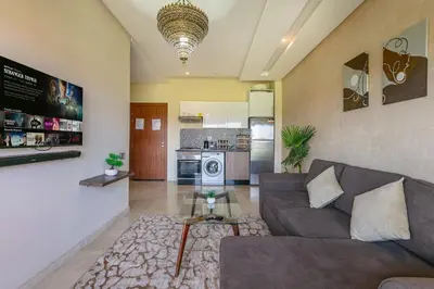a living room with a couch and a kitchen at Perle Rare a Prestigia - Vue Sur Golf in Marrakech