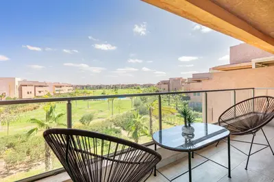a balcony with a table and chairs and a view at Perle Rare a Prestigia - Vue Sur Golf in Marrakech
