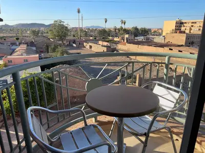 a table and two chairs on a balcony at Appartement 24 4èm étage avec balcon ( POUR FAMILLE ) in Marrakech