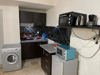 a small kitchen with a washer and a microwave at Appartement 25 4èm étage ( POUR FAMILLE ) in Marrakech