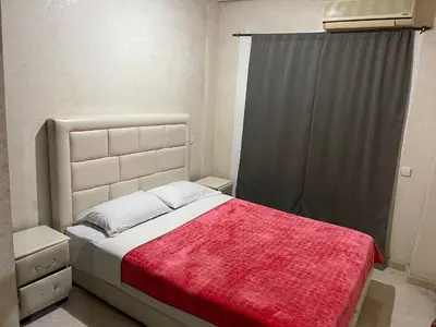 a small bedroom with a bed with a red blanket at Appartement 26 au 4ème étage avec balcon ( POUR FAMILLE ) in Marrakech