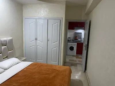 a small bedroom with a bed and a kitchen at Appartement 27 au 4ème étage ( POUR FAMILLE ) in Marrakech