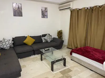 a living room with a couch and a table at Appartement 28 au 4 éme étage avec balcon ( POUR FAMILLE ) in Marrakech
