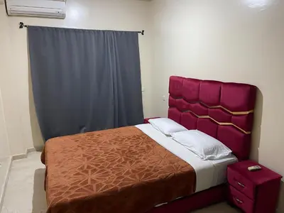 a bedroom with a large bed with a red headboard at Appartement 30 au 5 ème étage avec balcon ( POUR FAMILLE ) in Marrakech