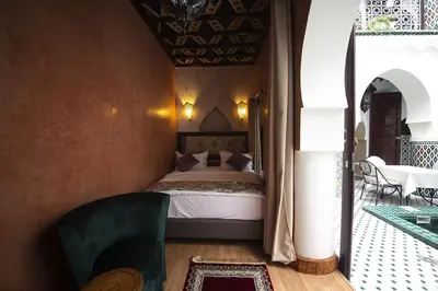 a bedroom with a bed and a table and chairs at Riad Maison Belbaraka in Marrakech