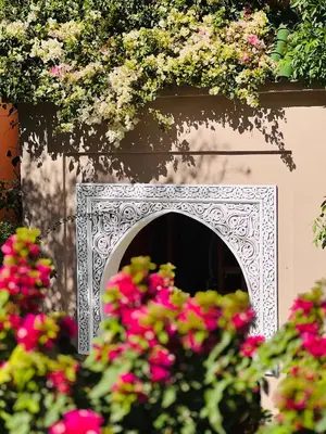 a white ornamental niche with flowers on a building at Pavillon du Golf - Palmeraie suites in Marrakech