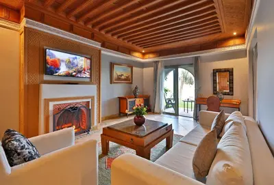 a living room with a couch and a fireplace at Pavillon du Golf - Palmeraie suites in Marrakech