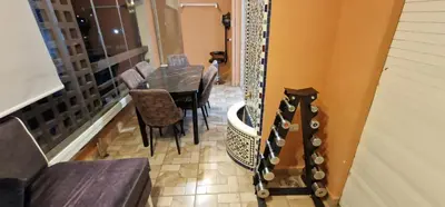 a dining room with a table and chairs and a guitar at Magnifique appartement à Riad Garden in Marrakech