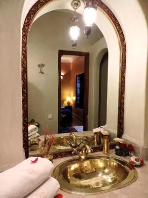 a bathroom with a sink and a large mirror at Riad Adriana in Marrakech