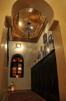 an arched hallway with a chandelier in a house at Riad Adriana in Marrakech