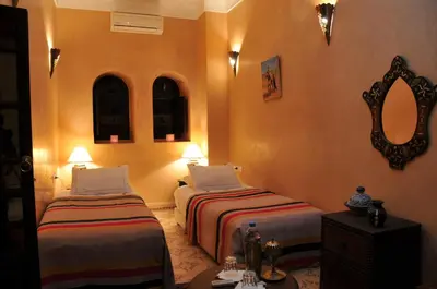 a hotel room with two beds and a mirror at Riad Adriana in Marrakech