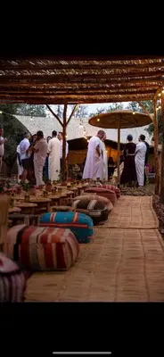 a group of people in white robes standing under a tent at La Ferme des Tipis Marrakech in Marrakech