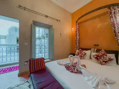 a bedroom with a large bed and a window at Riad L'Orchidée Suites & Spa in Marrakech
