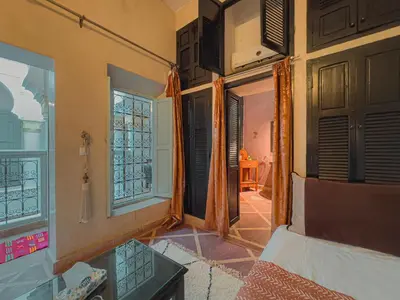 a room with a bed and a room with a window at Riad L'Orchidée Suites & Spa in Marrakech