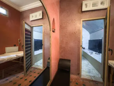 a room with a mirror and a bed and a balcony at Riad L'Orchidée Suites & Spa in Marrakech