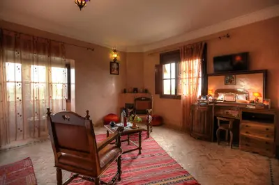 a living room with a chair and a table and a desk at Villa Dar Mya Palmiers in Marrakech