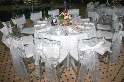 a table with white chairs and a white table cloth at Villa Dar Mya Palmiers in Marrakech