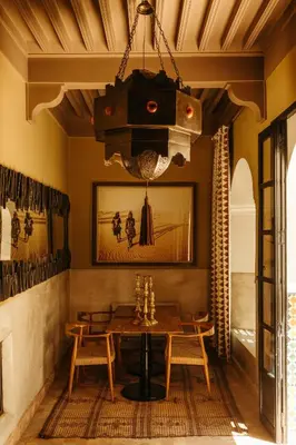 a dining room with a table and a chandelier at Ryad Dyor in Marrakech