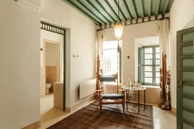 a living room with a table and a chair at Ryad Dyor in Marrakech