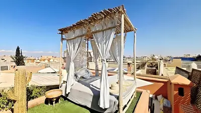 a canopy bed on top of a roof at Riad El Grably in Marrakech