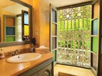 a bathroom with a sink and a glass window at Riad Dar Zouar & Spa in Marrakech