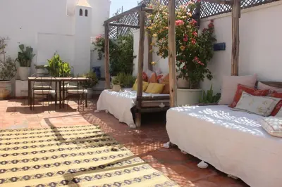 a bedroom with two beds and a table and a tableablish at Riad Dar Nael in Marrakech