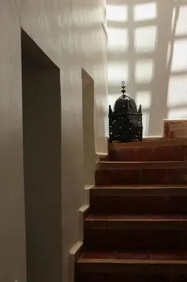 a set of stairs with a light shining through a window at Riad Dar Nael in Marrakech