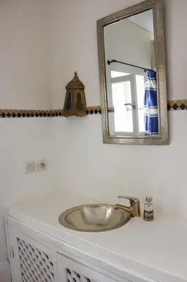 a bathroom sink with a mirror on top of it at Riad Dar Nael in Marrakech