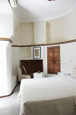 a bedroom with a large bed and a chair at Riad Dar Nael in Marrakech